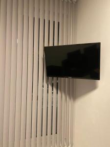 a flat screen tv hanging on a wall with vertical blinds at Pension MonaLisa in Bernkastel-Kues
