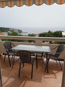 una mesa y sillas en un balcón con vistas al océano en Apartmani Vesna en Lun