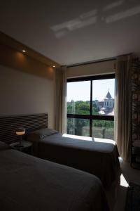 Habitación de hotel con 2 camas y ventana grande. en URBAN LIFE FLAT, en Verona