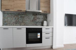 a kitchen with white cabinets and a black oven at Appartamento Tiffany in Brescia