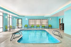 een zwembad in een kamer met stoelen en een tafel bij SpringHill Suites Boston Andover in Andover