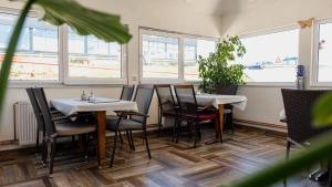 ドボイにあるGuesthouse "INES"のテーブルと椅子と窓のあるレストラン