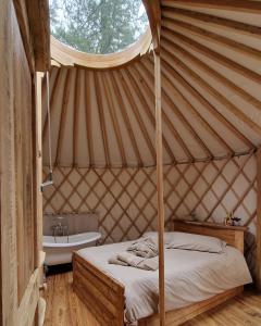 um quarto com uma cama e um lavatório numa tenda em MonvisoRelax em Ostana