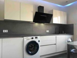 een keuken met een wasmachine in een witte keuken bij Schöne moderne Eigentumswohnung in Bochum-City in Bochum