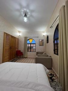 - une chambre avec un lit, un canapé et des fenêtres dans l'établissement Villa Essaouira, à Essaouira