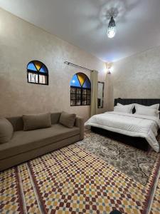 - une chambre avec un canapé, un lit et des fenêtres dans l'établissement Villa Essaouira, à Essaouira