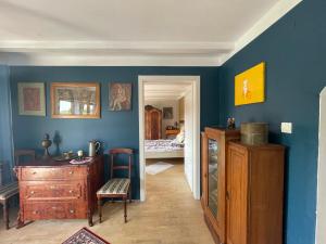 a room with blue walls and a wooden cabinet and a bedroom at Dom Pod Dobrym Drzewem in Inowłódz