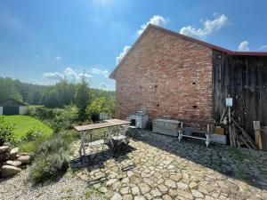 un edificio de ladrillo con una mesa de picnic al lado en Dom Pod Dobrym Drzewem, en Inowłódz