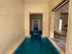 an empty room with a swimming pool in a building at Swahili Dreams Apartments in Lamu