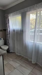 a bathroom with a toilet and a window at Tranquility on St James in Johannesburg +2 photos