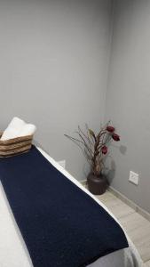a bedroom with a blue rug and a potted plant at Tranquility on St James in Johannesburg