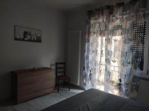 a bedroom with a bed and a dresser and a window at Angela in Garessio