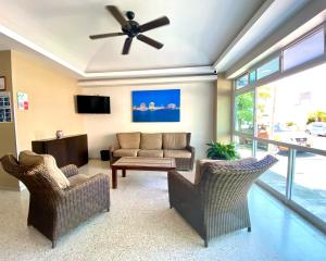 Hotel Delfines في فيراكروز: غرفة معيشة مع كرسيين ومروحة سقف