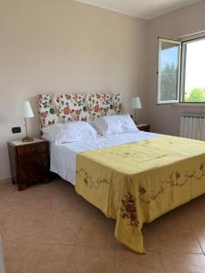 Un dormitorio con una cama grande con una manta amarilla. en Casa vacanze 365 - verde, en Tortoreto Lido