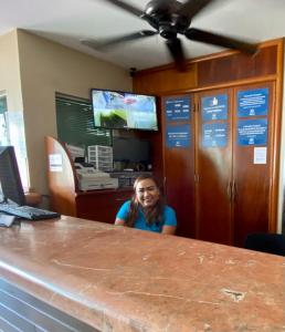 a woman sitting at a counter in an office at Hotel Delfines in Veracruz