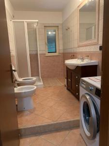 y baño con lavamanos y lavadora. en Casa vacanze 365 - verde, en Tortoreto Lido