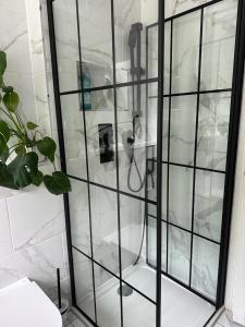 a shower with a glass partition in a bathroom at Large NEW Detached House Woolton, Families, FREE Parking, Massage, BBQ, Play room & MORE in Woolton