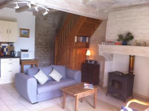 sala de estar con sofá y fogones en La Petite Maison, en Crézières