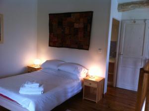 1 dormitorio con 1 cama y 2 luces en 2 mesas en La Petite Maison, en Crézières