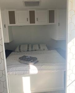 Una cama con dos toallas encima. en Comfy stay in private 2beds, 1bath kitchen RV, en Escondido