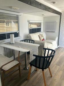sala de estar con mesa, sillas y sofá en Comfy stay in private 2beds, 1bath kitchen RV, en Escondido