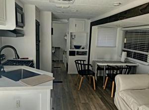 Comfy stay in private 2beds, 1bath kitchen RV في إسكونديدو: مطبخ وغرفة معيشة مع طاولة وكراسي