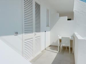 een witte kamer met een tafel en een witte muur bij La Casa sulla Spiaggia Torre San Giovanni in Torre San Giovanni Ugento