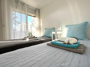 Un dormitorio con dos camas con almohadas azules y una ventana. en Studio Trip In Paris - Gare de l'Est, en París