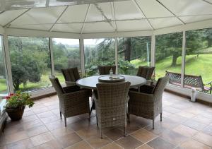 a conservatory with a table and chairs on a patio at The Retreat in Blackawton