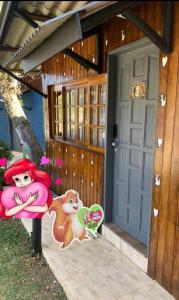 una puerta a una casa con un pony de dibujos animados en ella en Chale Sabrina, en Campos do Jordão
