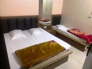 1 Schlafzimmer mit 2 Betten und einem Spiegel in der Unterkunft 5 Mint Walking from Dargah Hotel Dabi Palace in Ajmer