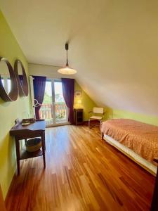 Schlafzimmer mit einem Bett, einem Schreibtisch und einem Fenster in der Unterkunft Maison à louer in Saint-Prex