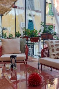 een balkon met twee banken en een tafel en planten bij La Terrazza al Museo in Napels