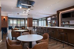 un ristorante con tavoli e sedie e un bar di Courtyard by Marriott Austin Dripping Springs a Dripping Springs