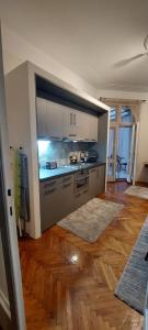 a kitchen with white cabinets and a wooden floor at Bohemian in Belgrade
