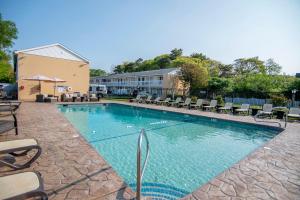 une piscine avec des chaises et un bâtiment dans l'établissement Cape Colony Inn, à Provincetown