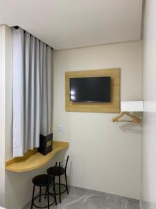 聖保羅的住宿－Hotel Urban，一间设有两把椅子和一台墙上的电视的房间