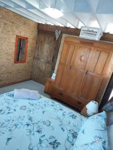 a bedroom with a large bed and a wooden door at Penelope Selfcatering Apartment in Wilderness