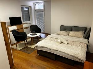 1 dormitorio con 1 cama, mesa y sillas en Apartmani Venci Travnik en Travnik