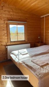 a bedroom with a bed in a log cabin at Armuli in Reynistaður