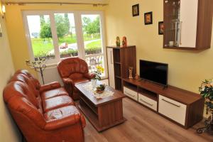 a living room with two chairs and a television at Vila Václav in Podhájska