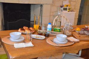una mesa de madera con platos de comida. en Chambre Gargantua Le dolmen, en Thizay