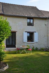 a house with a table and chairs in the yard at Chambre Gargantua Le dolmen in Thizay