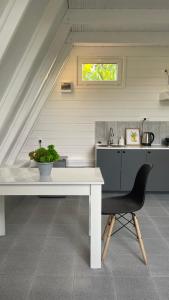 uma cozinha com uma mesa branca e uma cadeira preta em Дом Aframe Пицунда em Pizunda