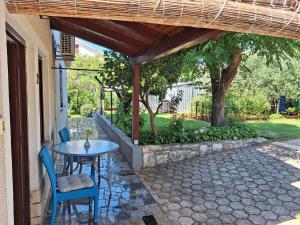 a patio with a table and chairs under a pergola at Apartments Reinić in Novigrad Istria