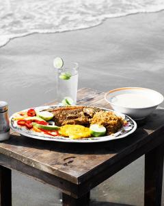 un plato de comida sobre una mesa de madera en HOSTAL LA BOQUILLA, en Cartagena de Indias