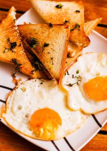 a plate of eggs and toast and bread on a table at HOSTAL LA BOQUILLA in Cartagena de Indias