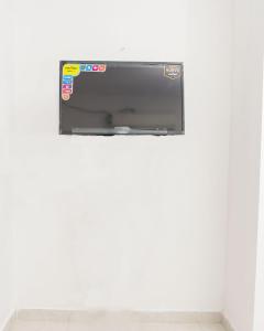 una TV a schermo piatto appesa a un muro bianco di HOSTAL LA BOQUILLA a Cartagena de Indias