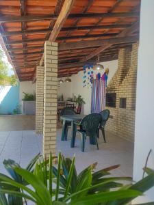 un patio con tavolo e sedie su un patio di Vivenda das Águas Guarajuba a Guarajuba