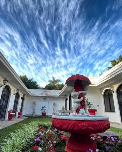 una casa con una fuente roja en el patio en Biazi Paradise Hotel, en Serra Negra